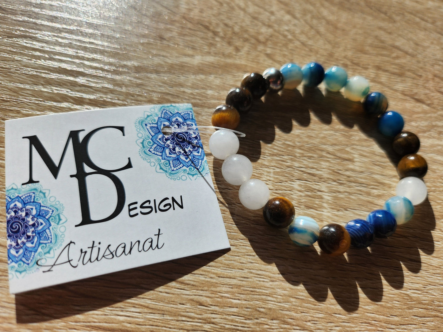 Bracelet en pierre semi-précieuses avec billes de 8mm. Billes d'agate bleue facettés, Quartz snow et oeil de tigre jaune.