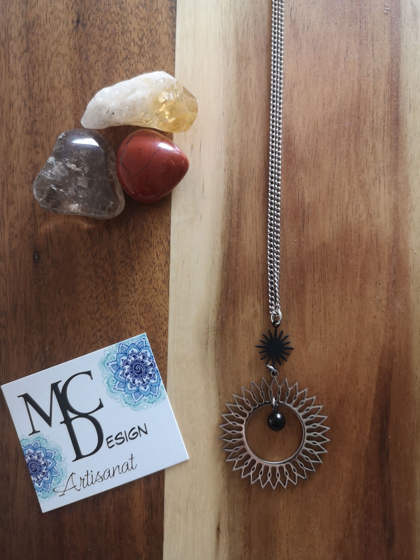Magnifique collier long, fait avec 2 breloques soleil noir et argent. Collier très versatile et se porte avec beaucoup de style.