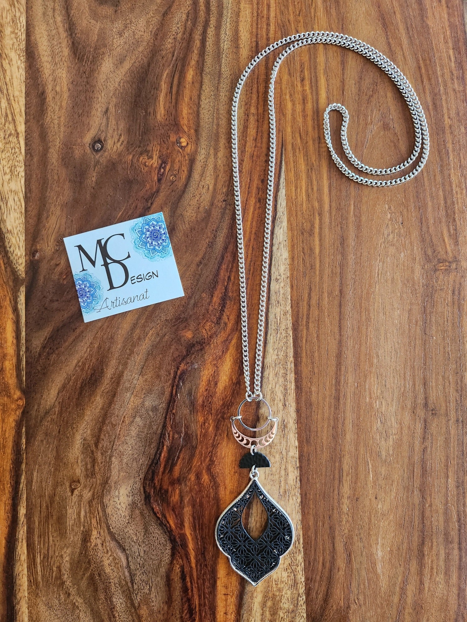 Superbe collier inox avec croissant de lune et breloques noires.