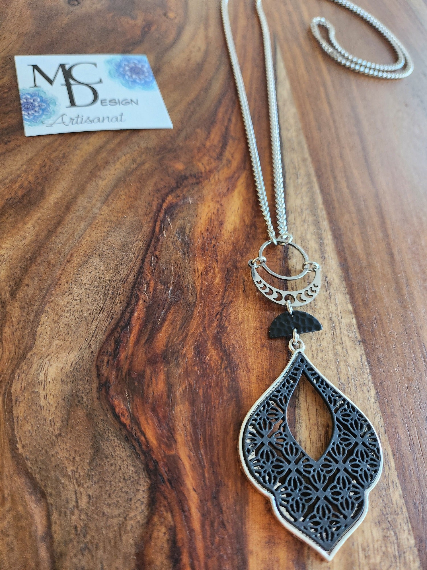 Superbe collier inox avec croissant de lune et breloques noires.
