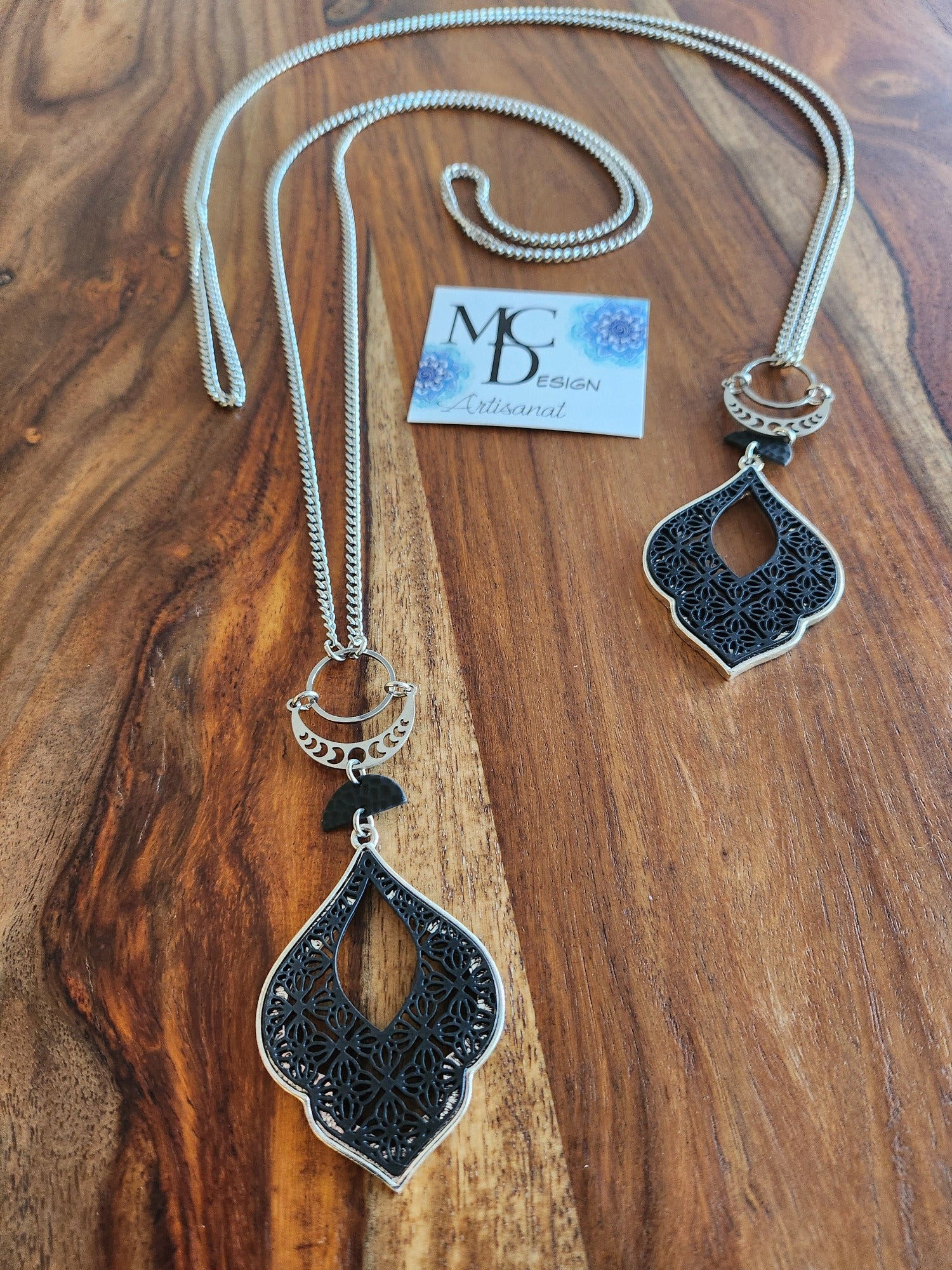 Superbe collier inox avec croissant de lune et breloques noires.