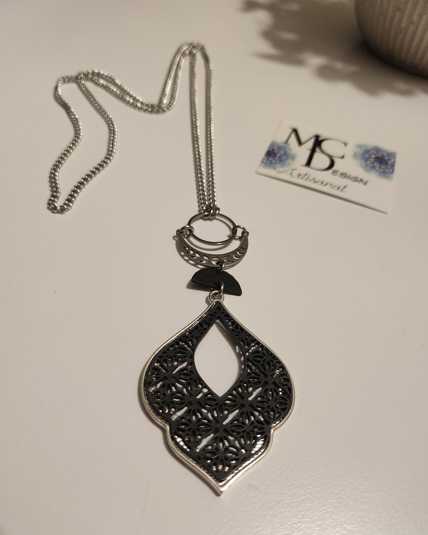 Superbe collier inox avec croissant de lune et breloques noires.
