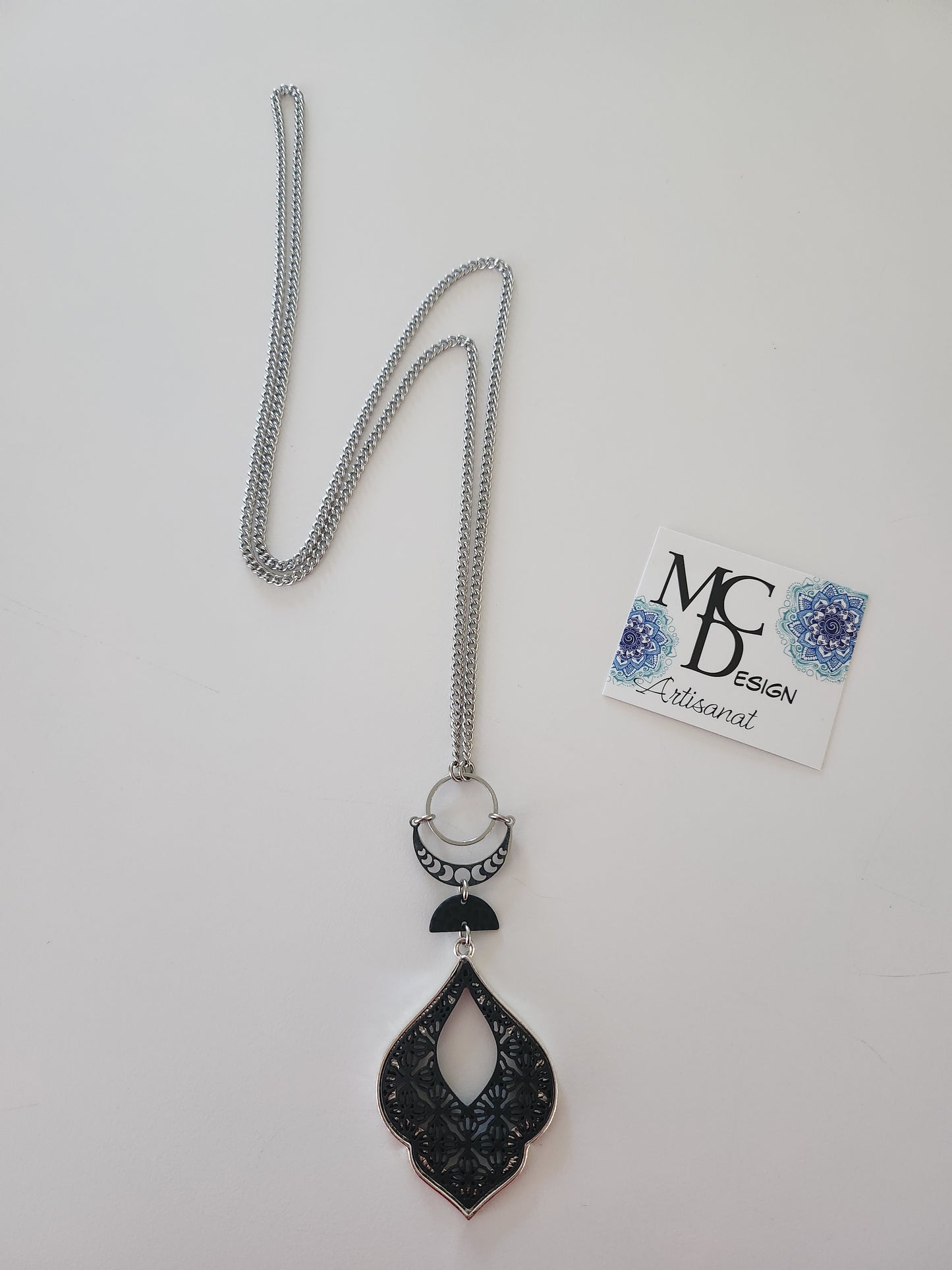 Superbe collier inox avec croissant de lune et breloques noires.