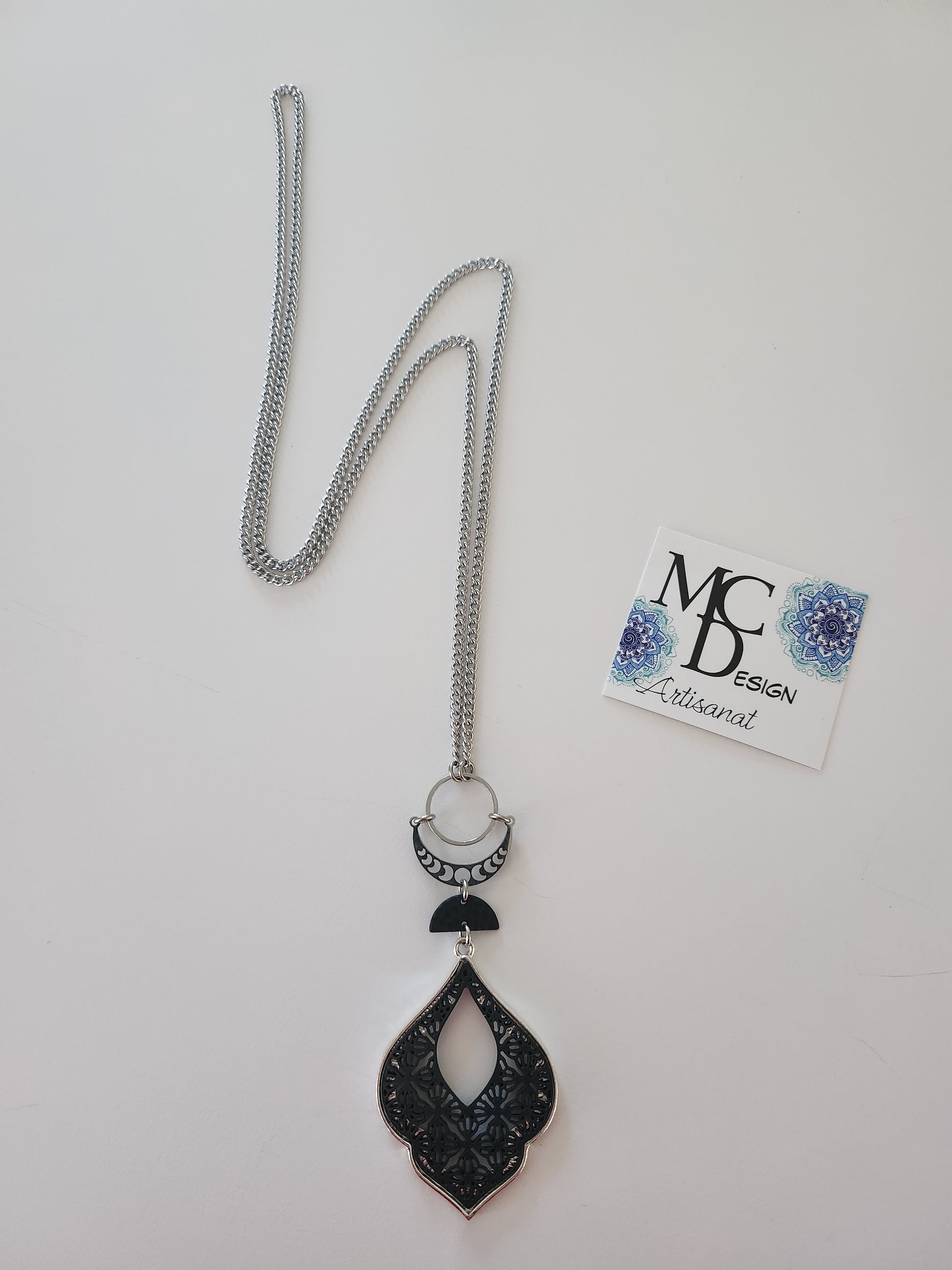 Superbe collier inox avec croissant de lune et breloques noires.