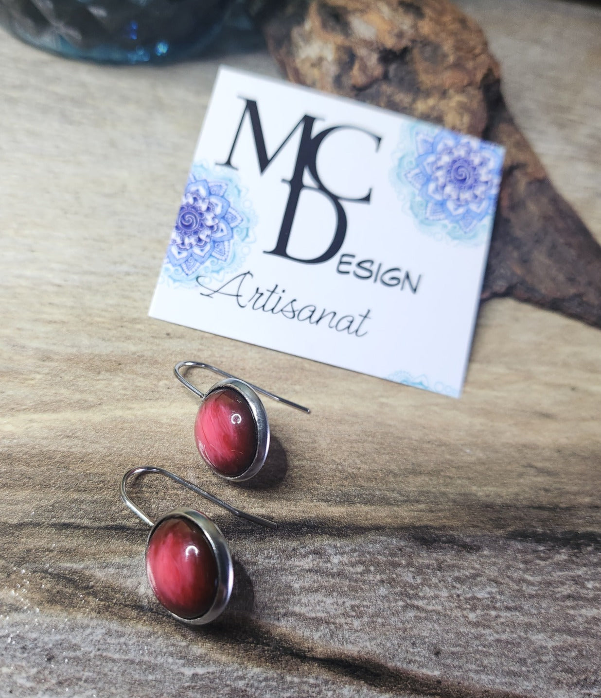Boucles d'oreilles fais de bois, de résine et acier inoxydable de grandeur 12mm de couleur rouge, disponible en version clous d'oreilles, style dormeuse et en version pendante avec breloque en inox.