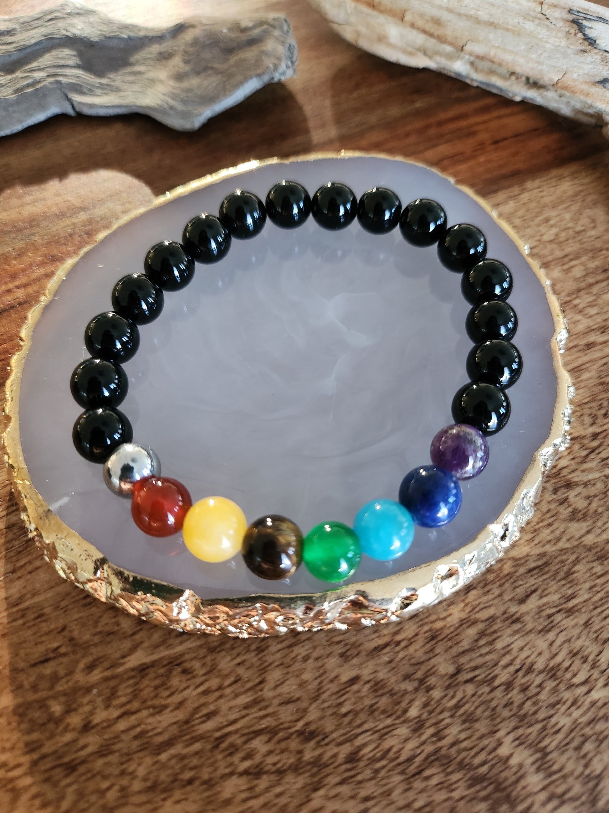 Bracelet en pierre semi-précieuses avec billes de 8mm. Onyx noir  et 7 chakras : Améthyste, Lapis Lazuli, Apatite, Jade, Oeil de tigre jaune, Calcite, Agate orange.