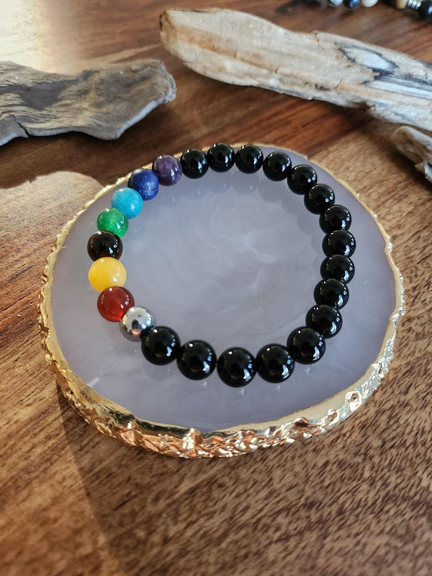 Bracelet en pierre semi-précieuses avec billes de 8mm. Onyx noir  et 7 chakras : Améthyste, Lapis Lazuli, Apatite, Jade, Oeil de tigre jaune, Calcite, Agate orange.