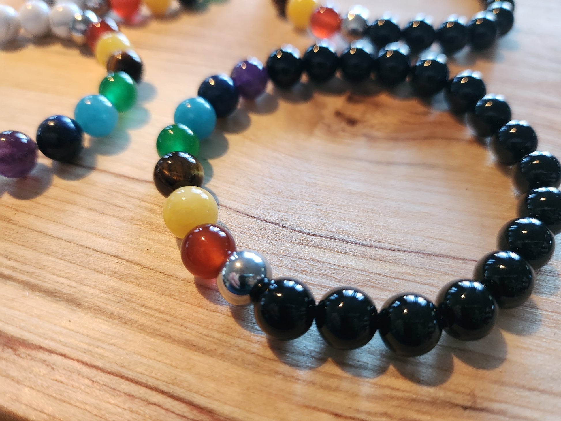 Bracelet en pierre semi-précieuses avec billes de 8mm. Onyx noir  et 7 chakras : Améthyste, Lapis Lazuli, Apatite, Jade, Oeil de tigre jaune, Calcite, Agate orange.