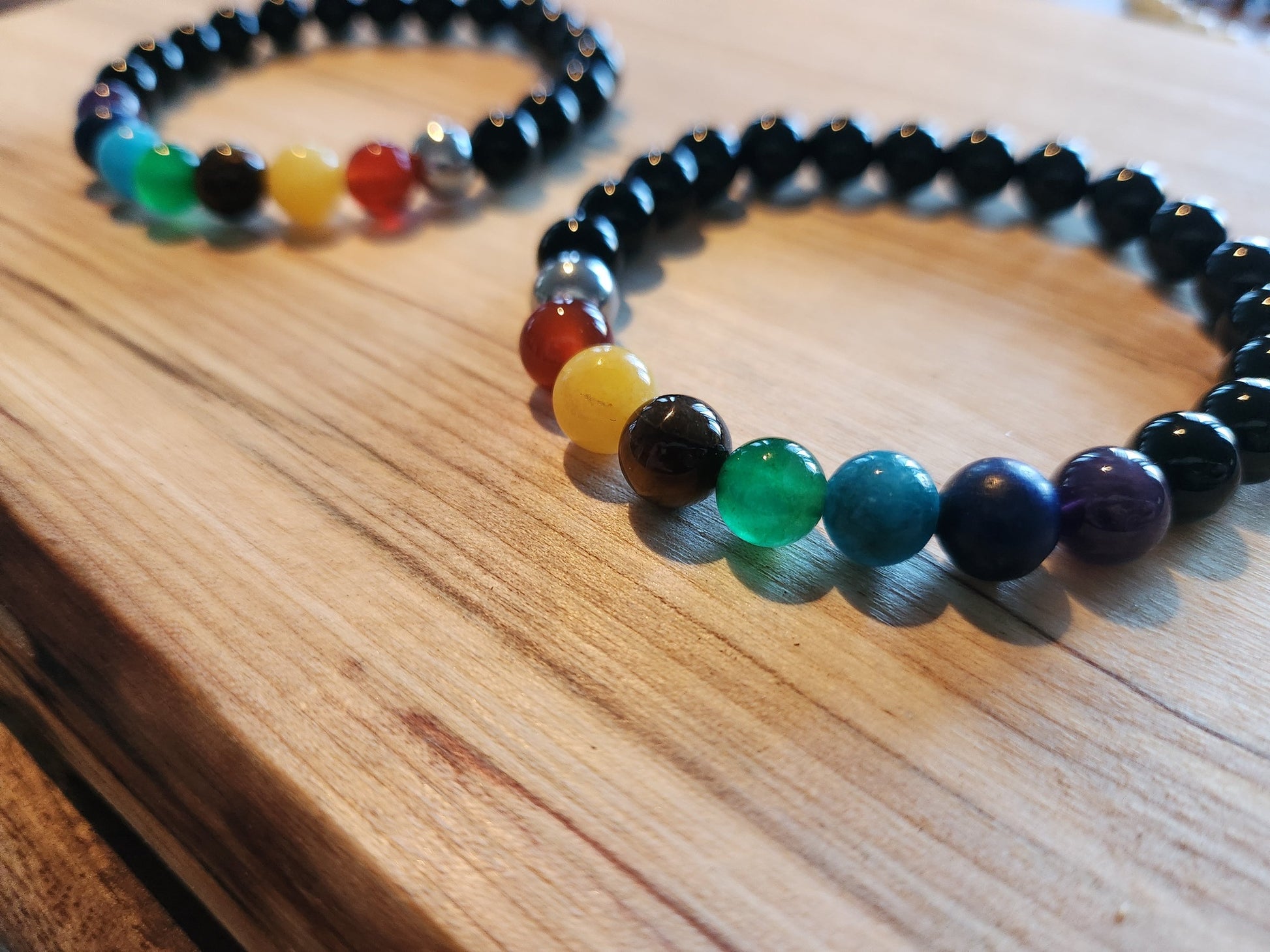 Bracelet en pierre semi-précieuses avec billes de 8mm. Onyx noir  et 7 chakras : Améthyste, Lapis Lazuli, Apatite, Jade, Oeil de tigre jaune, Calcite, Agate orange.
