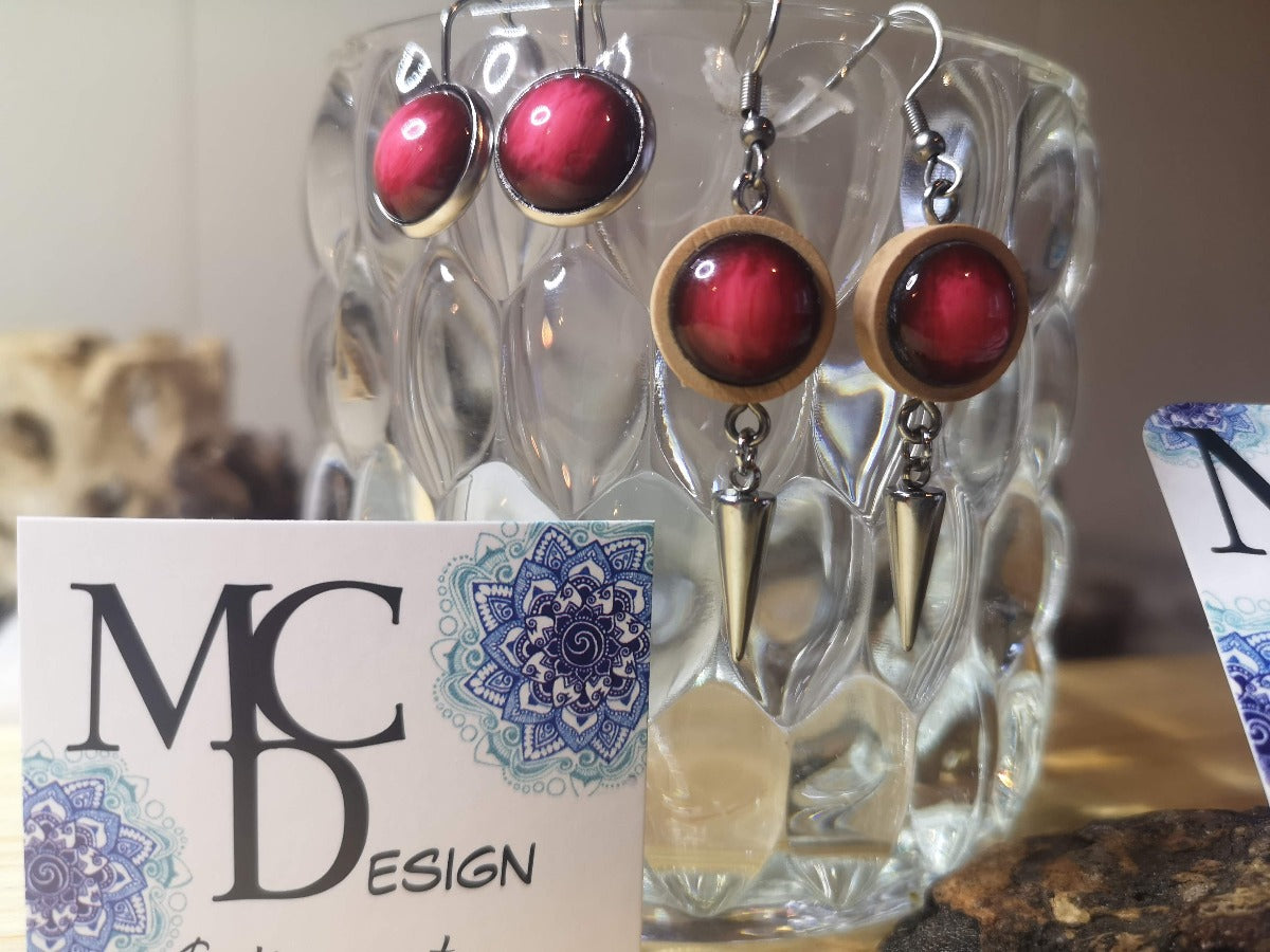 Boucles d'oreilles fais de bois, de résine et acier inoxydable de grandeur 12mm de couleur rouge, disponible en version clous d'oreilles, style dormeuse et en version pendante avec breloque en inox.