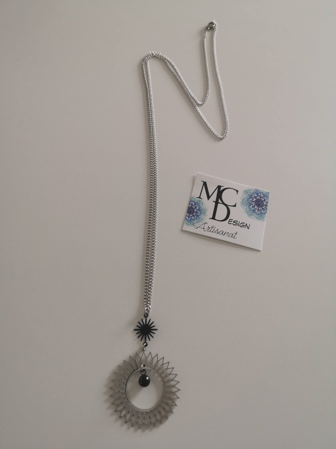 Magnifique collier long, fait avec 2 breloques soleil noir et argent. Collier très versatile et se porte avec beaucoup de style.