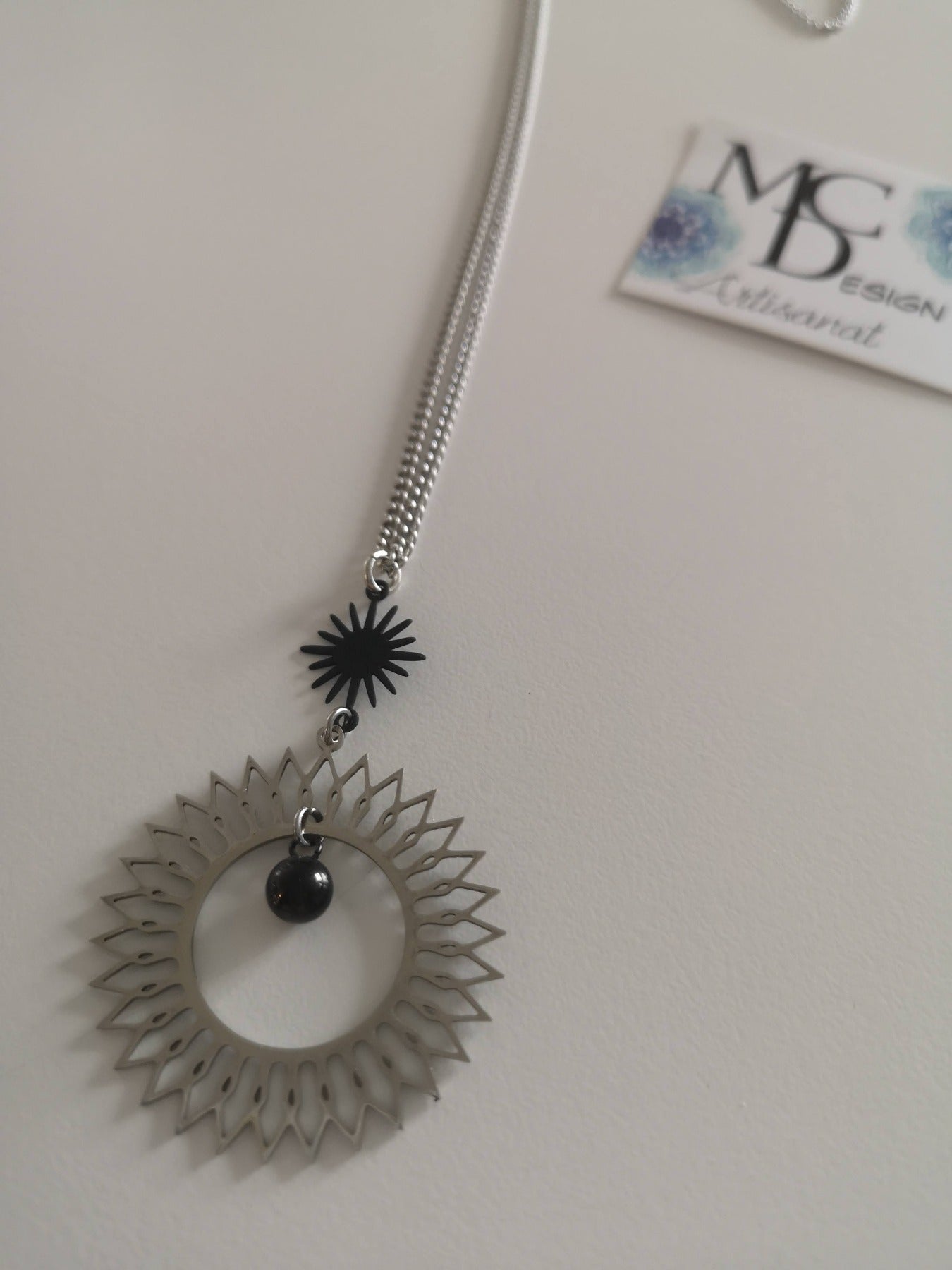 Magnifique collier long, fait avec 2 breloques soleil noir et argent. Collier très versatile et se porte avec beaucoup de style.
