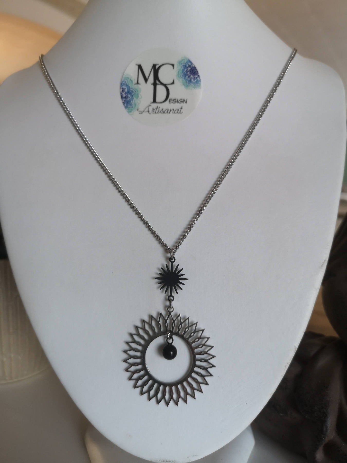 Magnifique collier long, fait avec 2 breloques soleil noir et argent. Collier très versatile et se porte avec beaucoup de style.