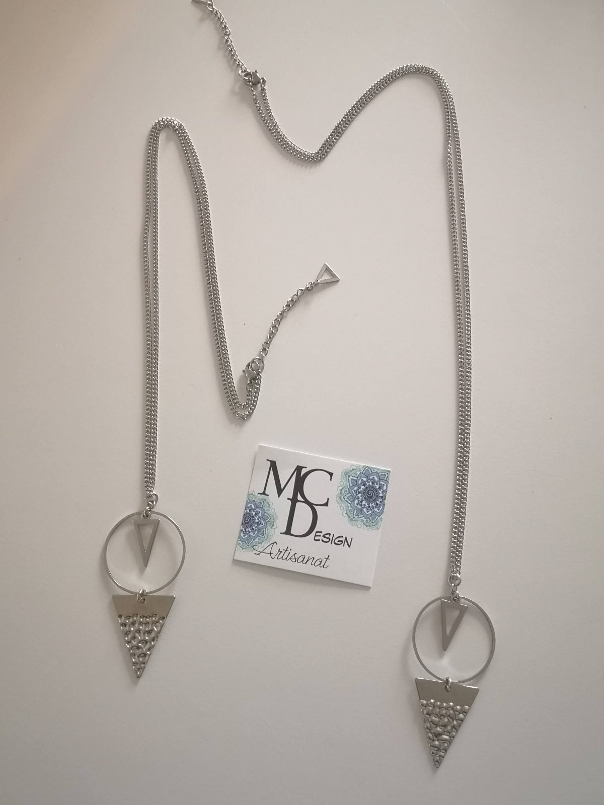 Magnifique collier long, fait avec 2 breloques triangles + un cercle. Collier très versatile et se porte avec beaucoup de style.